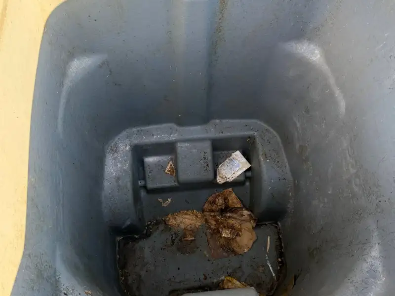 dirty gray outdoor trash bin before cleaning